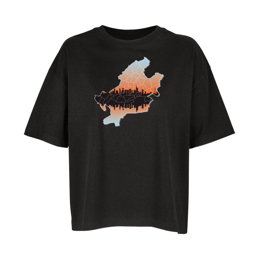 Ein schwarzes Oversize-Shirt, darauf die Karte von Frankfurt. Die Karte selbst hat einen Hintergrund, der von oben hellblau, in der Mitte Orange nach unten wieder nach hellblau verläuft. Etwas unterhalb ihrer Mitte ist die Skyline von Frankfurt in der Karte, in Schwarz. Einmal richtig herum und dann einmal gespiegelt und leicht verzerrt, als würde sie sich im Wasser spiegeln. Noch über allen Inhalten zeichnen weiße Linien die Stadtteile ein.