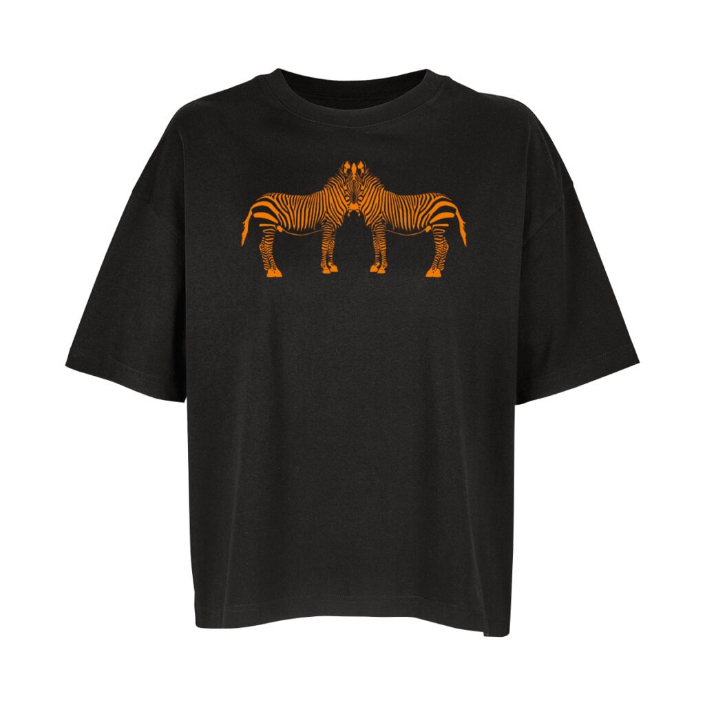 Ein schwarzes Oversize-Shirt, darauf zwei stilisierte Zebras, bestehend aus orangefarbenen Streifen, die sonst die schwarzen Streifen des Zebras wären. Von der Seite gezeichnet, sodass zwei Körper sichtbar sind, die aber in einem Kopf verschmelzen.